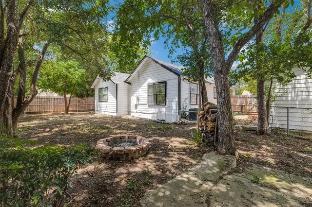 a backyard of a house with table and chairs