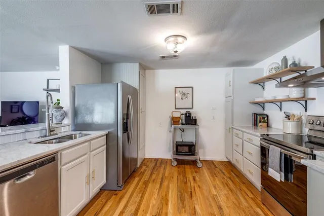 a kitchen with stainless steel appliances a sink stove and refrigerator