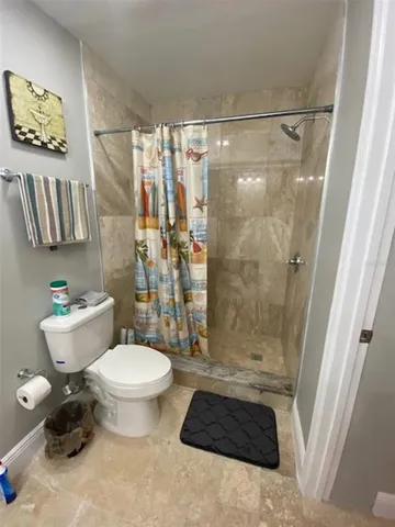 a bathroom with a toilet and a shower