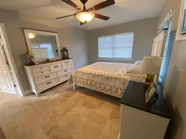 a bedroom with a bed and a flat tv screen on the dresser