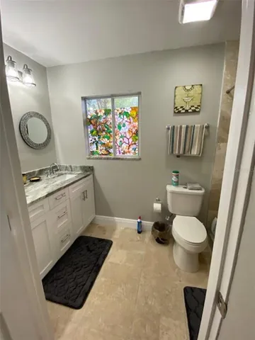 a bathroom with a toilet a sink and a mirror