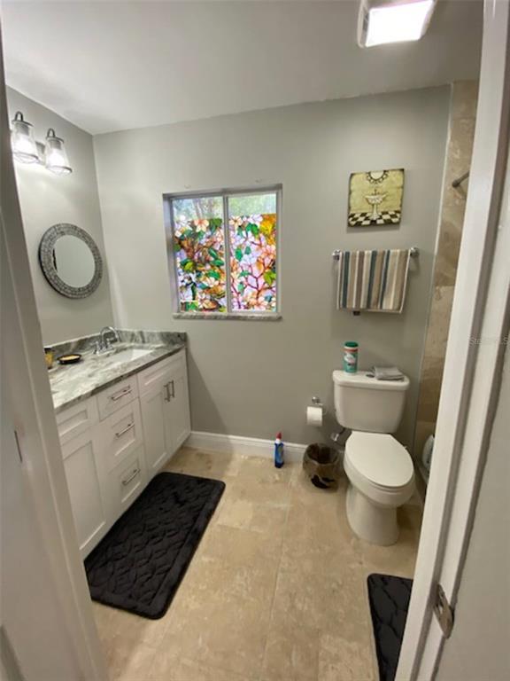 508 Ulelah Avenue Palm Harbor, FL 34683 - Photo 10 of 18 a bathroom with a toilet a sink and a mirror