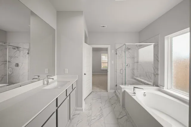 a bathroom with a tub a sink a mirror and a shower