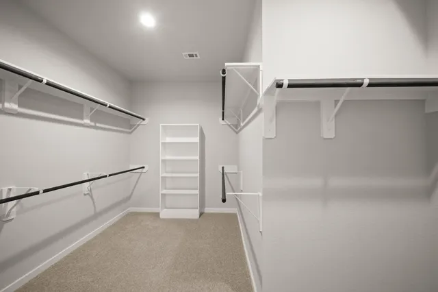 a view of walk in closet with empty racks