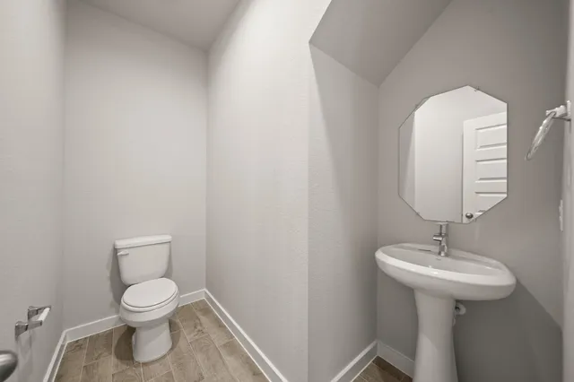 a bathroom with a toilet a sink and mirror