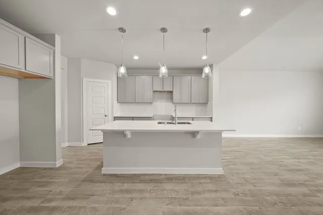 a view of kitchen with kitchen island a sink stainless steel appliances and cabinets