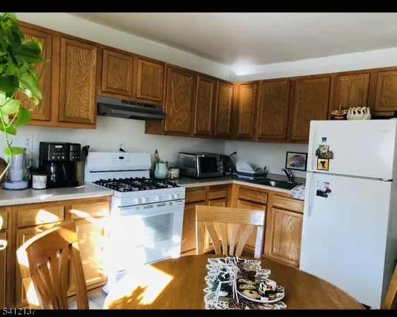a kitchen with a refrigerator a stove a sink and cabinets