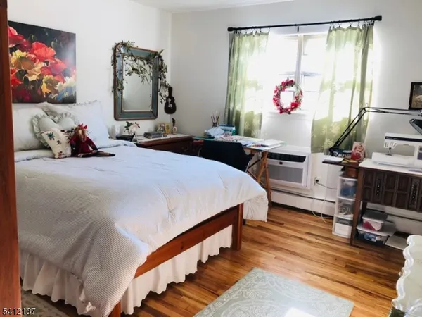 a bedroom with bed and a painting on the wall
