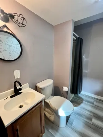a bathroom with a toilet sink and mirror