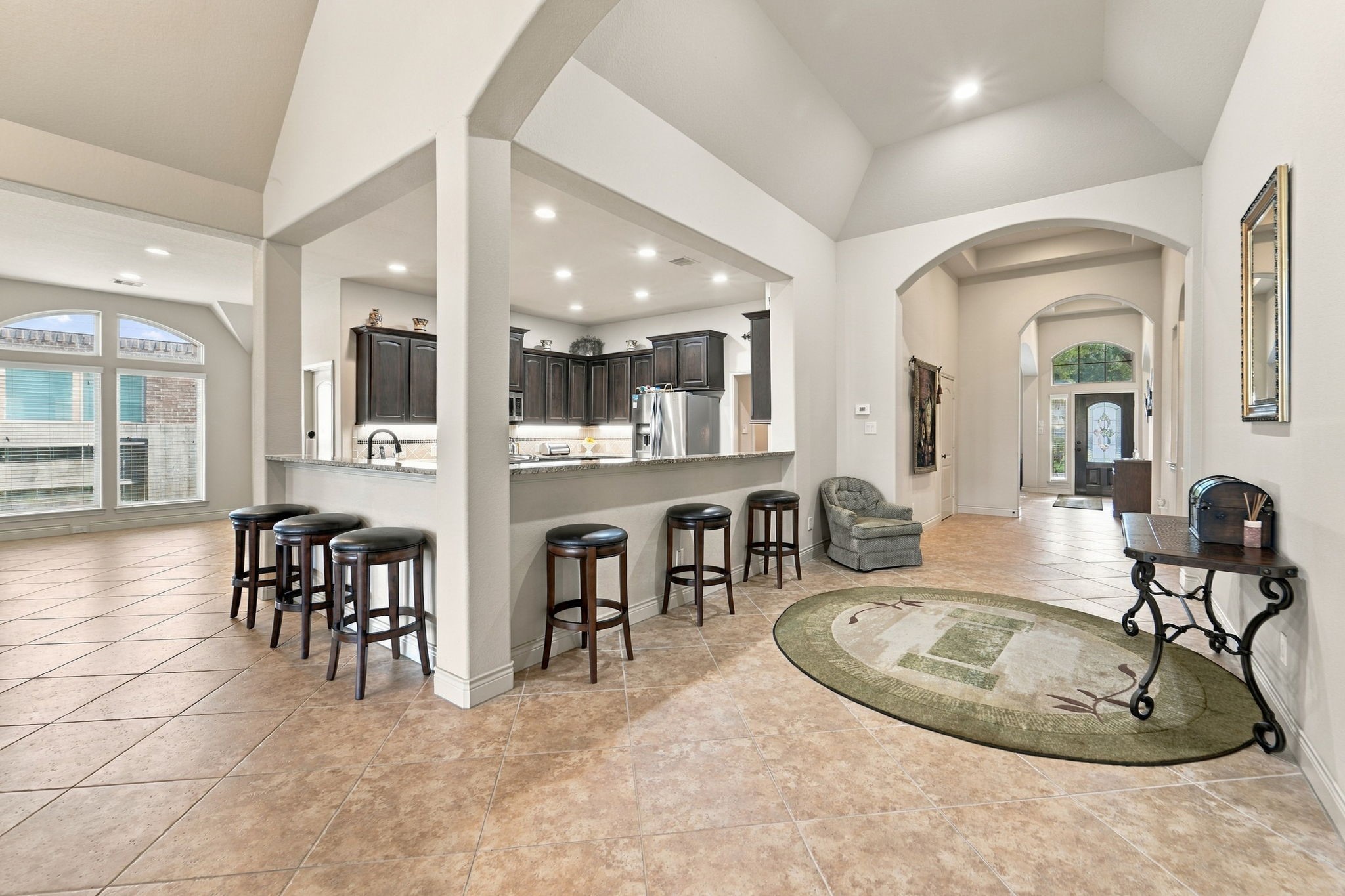 9818 Reston Ranch Court Cypress, TX 77433 - Photo 29 of 38 Offers an open and airy feel with seamless connectivity between the kitchen, entry, and living areas. The raised breakfast bar provides extra seating, perfect for entertaining guests.