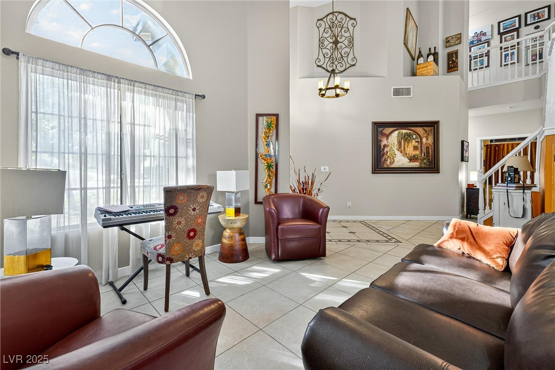 980 Upper Meadows Place Henderson, NV 89052 - Photo 16 of 58 Living area with tile patterned floors, a high ceiling, and a chandelier