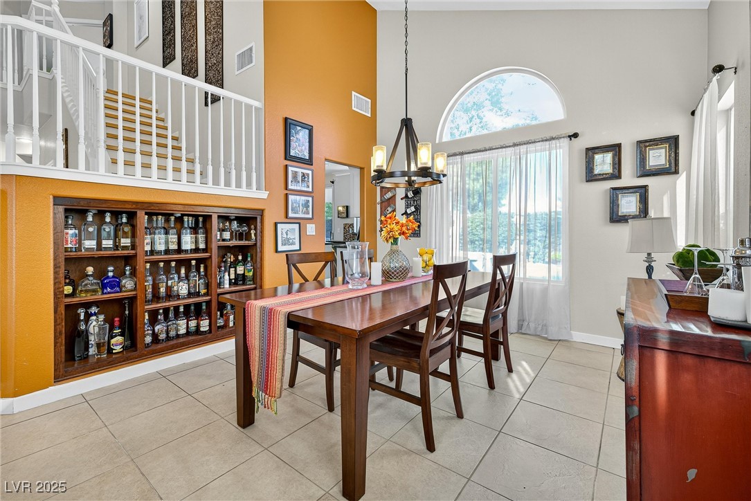 980 Upper Meadows Place Henderson, NV 89052 - Photo 17 of 58 Dining room with a high ceiling, light tile patterned flooring, and a chandelier