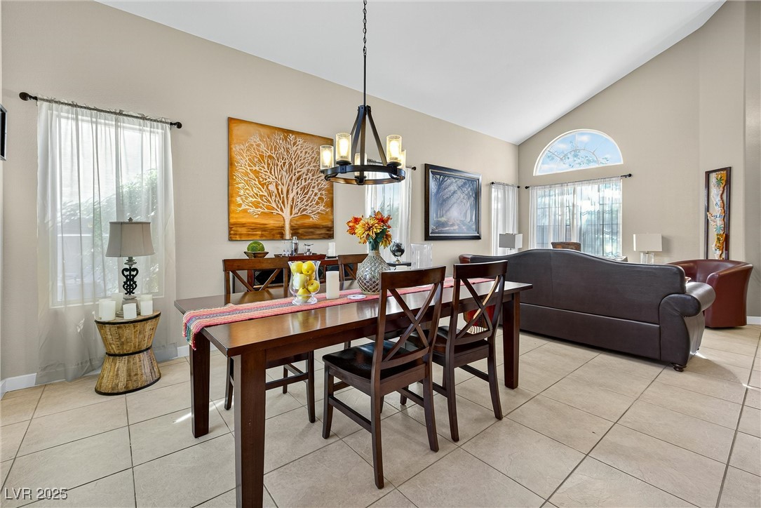 980 Upper Meadows Place Henderson, NV 89052 - Photo 18 of 58 Dining area with high vaulted ceiling, light tile patterned floors, and a chandelier