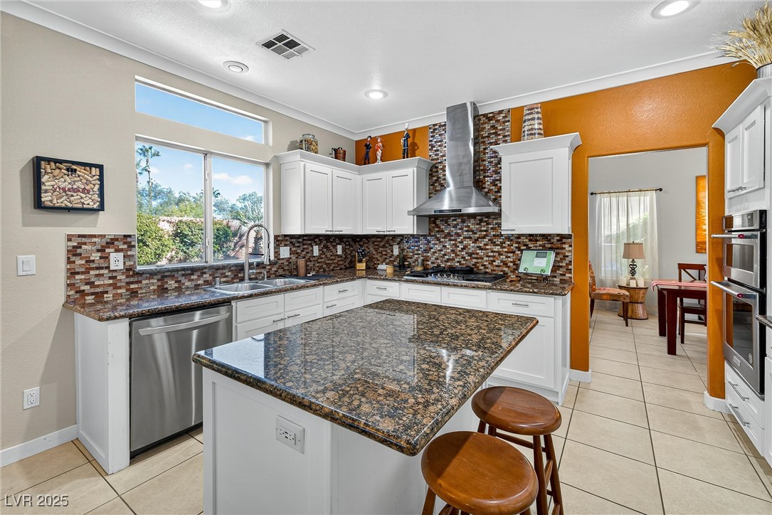980 Upper Meadows Place Henderson, NV 89052 - Photo 19 of 58 Kitchen featuring tasteful backsplash, white cabinets, dark stone countertops, appliances with stainless steel finishes, and recessed lighting