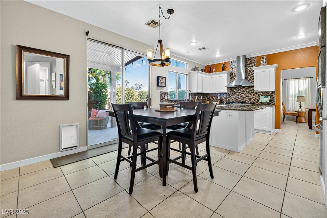 980 Upper Meadows Place Henderson, NV 89052 - Photo 21 of 58 Dining room with light tile patterned floors, a chandelier, and crown molding