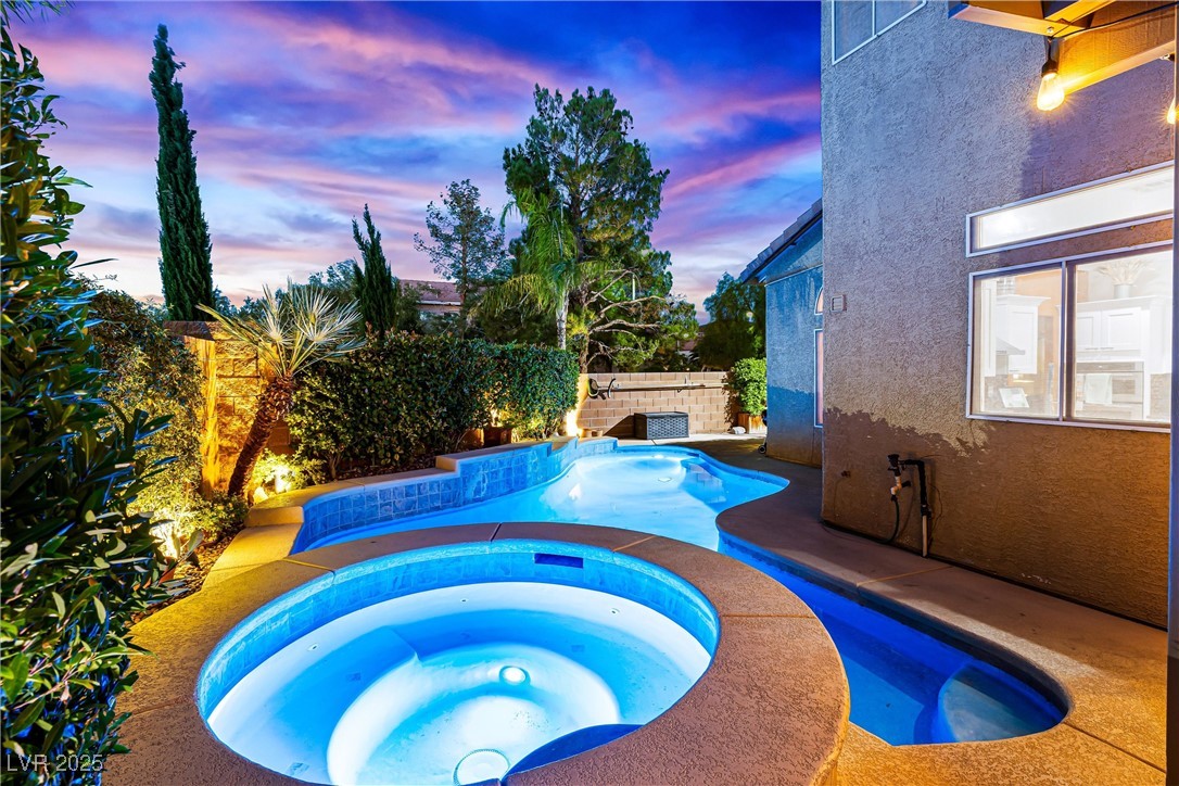 980 Upper Meadows Place Henderson, NV 89052 - Photo 5 of 58 Pool at dusk with an in-ground hot tub, a patio area, and a fenced backyard