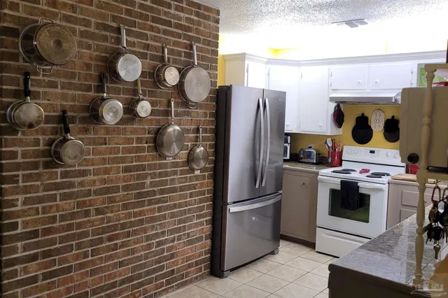 a table with white cabinets and wooden floor