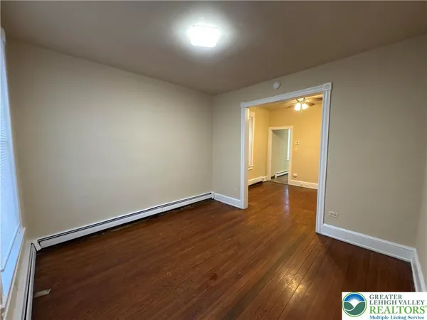 an empty room with wooden floor and a window