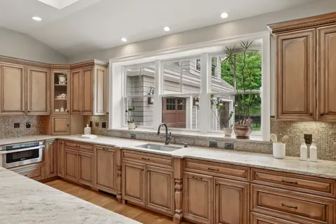 a kitchen with stainless steel appliances granite countertop a sink stove and cabinets
