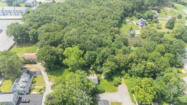 an aerial view of residential houses with outdoor space and trees