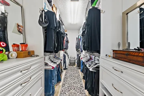 a view of walk in closet with clothes and shoes