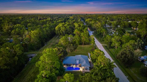 an aerial view of residential houses with outdoor space and trees