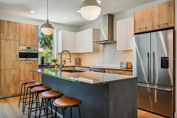 a kitchen with stainless steel appliances granite countertop a sink refrigerator a stove a microwave oven with a dining table and chairs