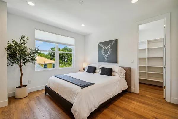a bedroom with a bed and a potted plant