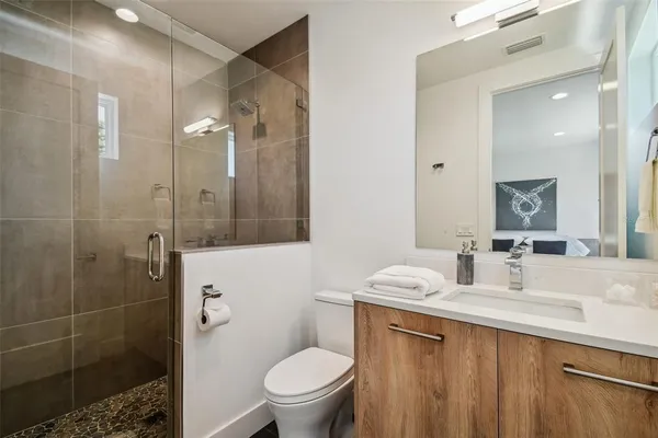 a bathroom with a double vanity sink toilet and shower