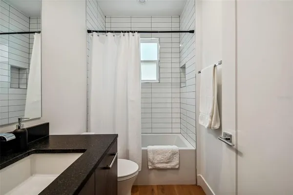 a bathroom with a granite countertop sink toilet and shower