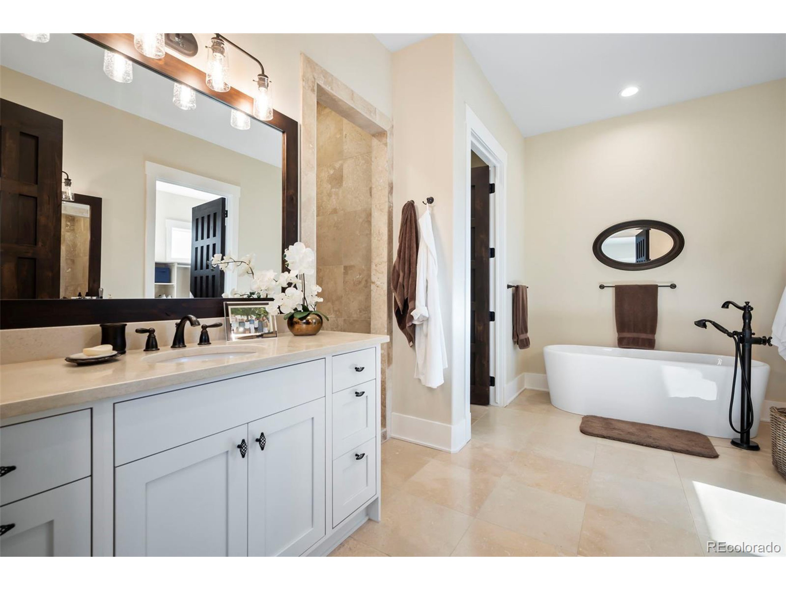 4694 Settlers Ridge Road Colorado Springs, CO 80908 - Photo 14 of 43 a spacious bathroom with a double vanity sink a mirror and a bathtub