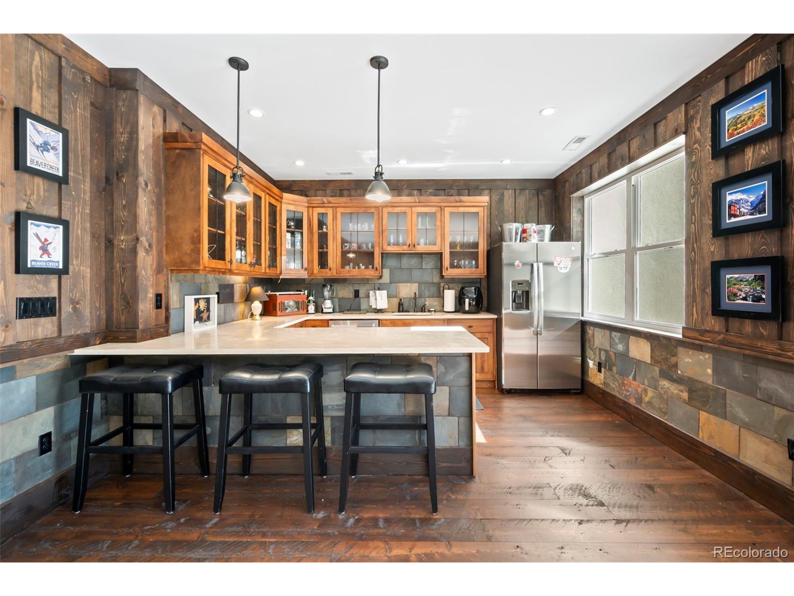 4694 Settlers Ridge Road Colorado Springs, CO 80908 - Photo 24 of 43 a dining hall with stainless steel appliances kitchen island granite countertop a table chairs and a large window