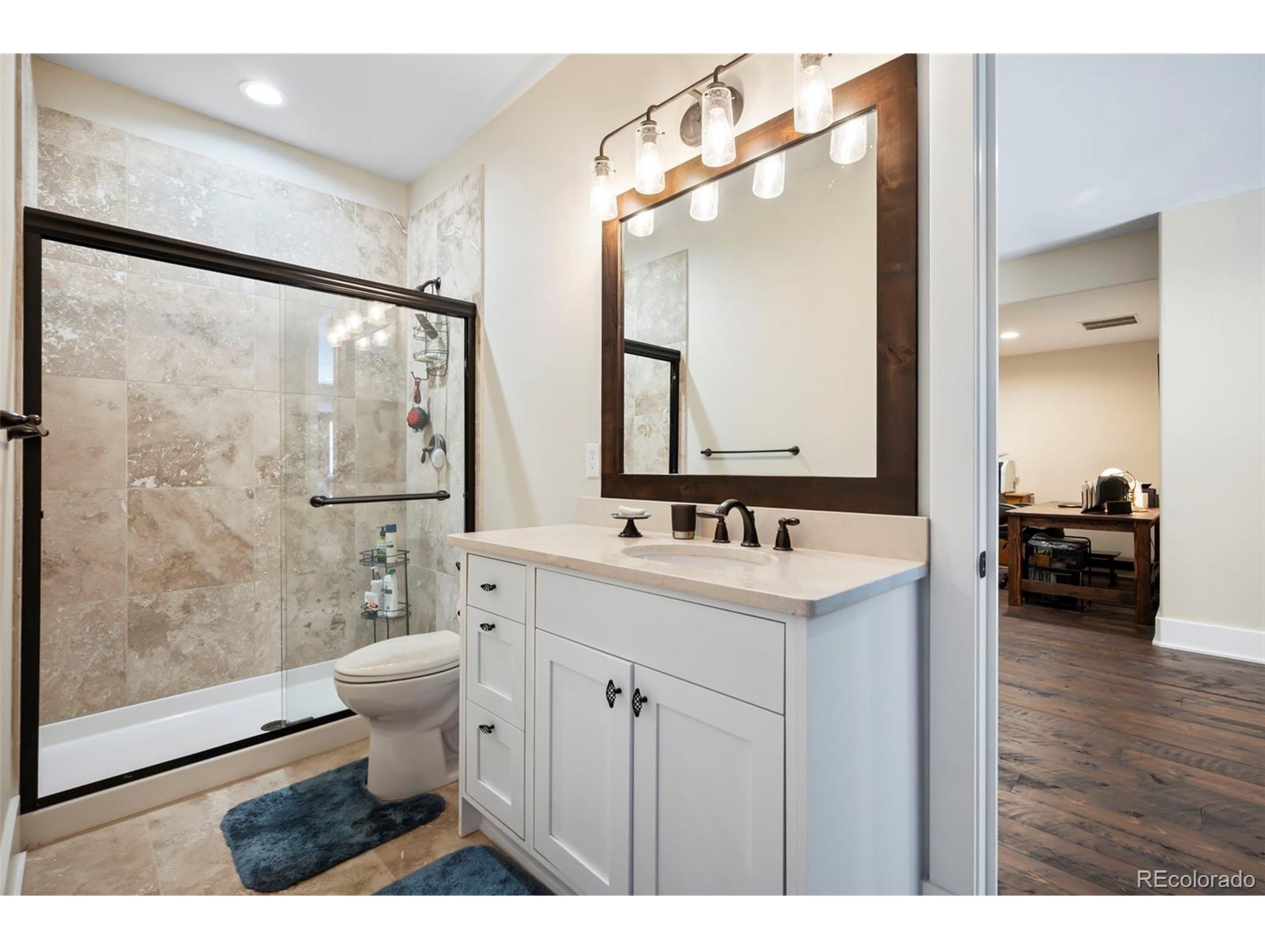 4694 Settlers Ridge Road Colorado Springs, CO 80908 - Photo 28 of 43 a bathroom with a sink toilet a mirror and shower