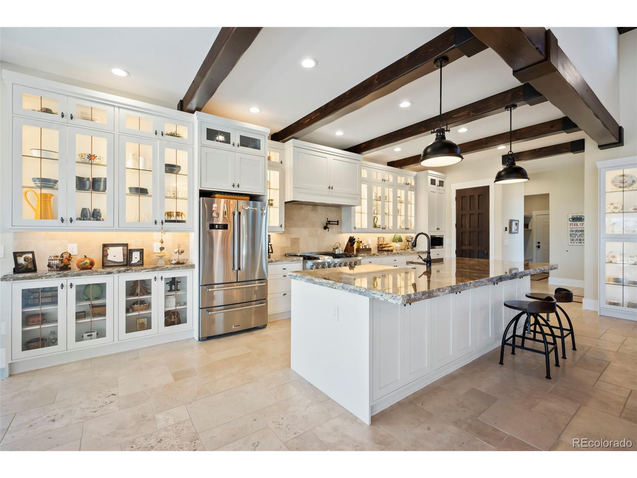 4694 Settlers Ridge Road Colorado Springs, CO 80908 - Photo 6 of 43 a kitchen with stainless steel appliances kitchen island granite countertop a stove and a refrigerator