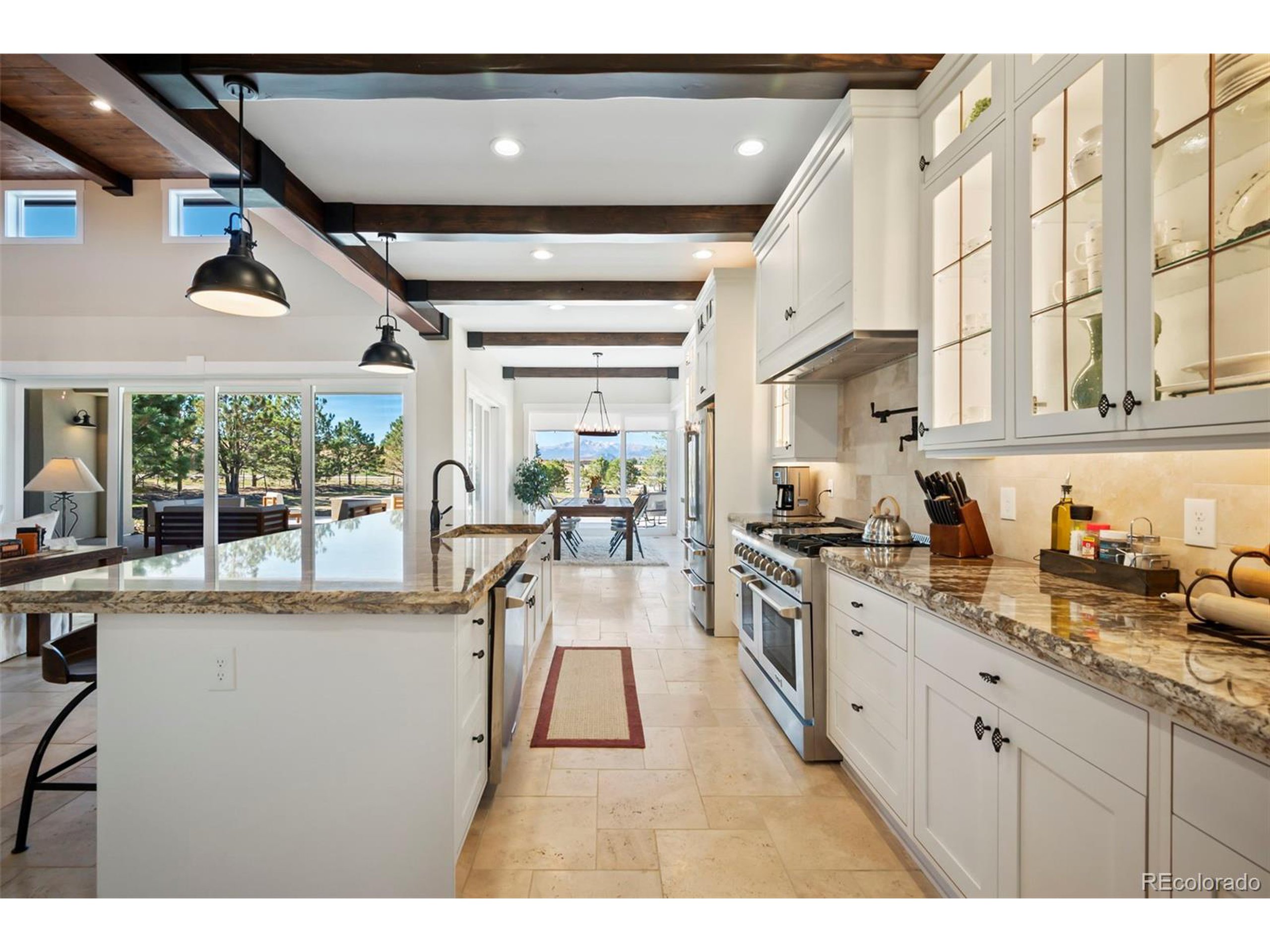 4694 Settlers Ridge Road Colorado Springs, CO 80908 - Photo 9 of 43 a open kitchen with stainless steel appliances granite countertop a lot of cabinets a sink and wooden floors