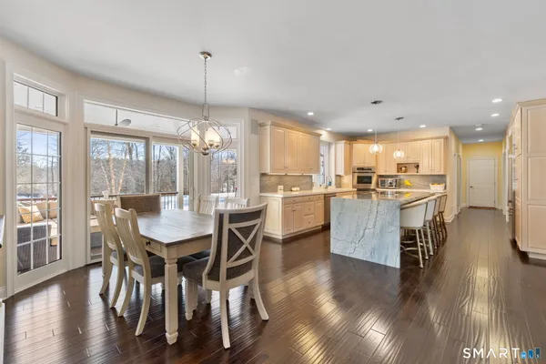 a view of a dining room and livingroom with furniture wooden floor a chandelier