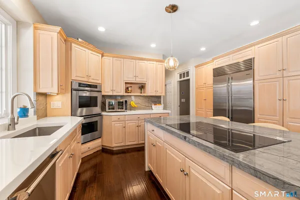 a kitchen with stainless steel appliances a sink a stove and white cabinets