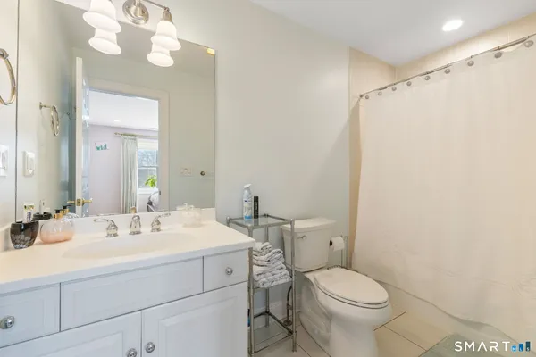 a bathroom with a sink mirror vanity and toilet