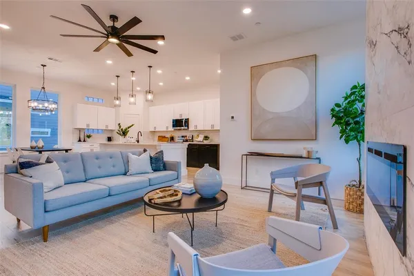 a living room with furniture kitchen and a chandelier