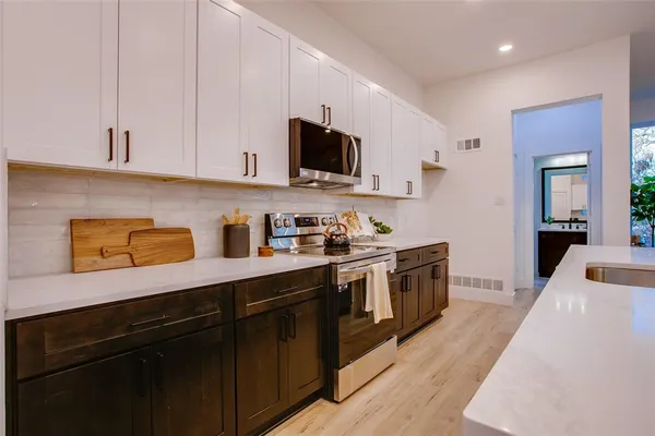 a kitchen with granite countertop a sink and steel appliances