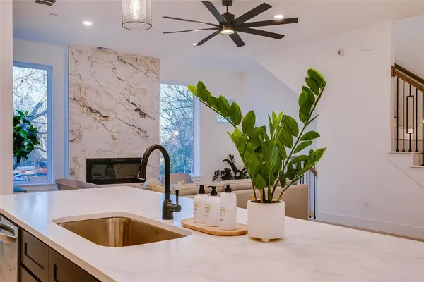 a close view of a faucet a sink and a dining table with a potted plant