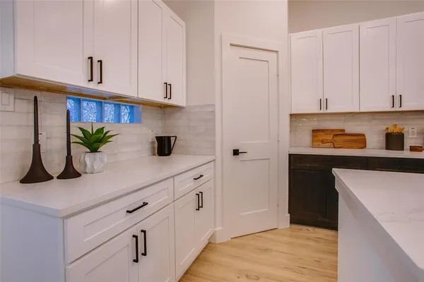 a kitchen with white cabinets and appliances