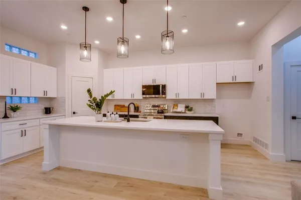 a kitchen with kitchen island a sink stainless steel appliances and cabinets