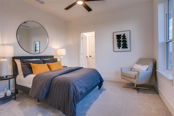 a bedroom with a bed a mirror and a potted plant