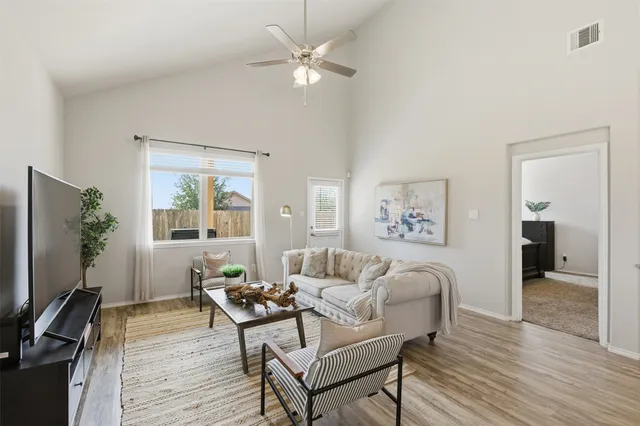 a living room with furniture a desk and a flat screen tv