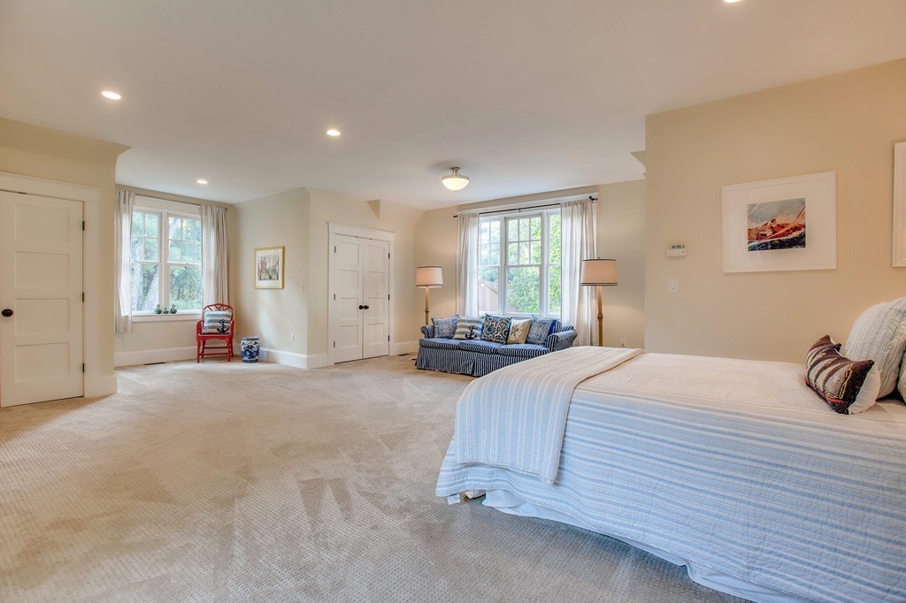 73 Weston Road Lincoln, MA 01773 - Photo 26 of 30 a spacious bedroom with a large bed and a chandelier
