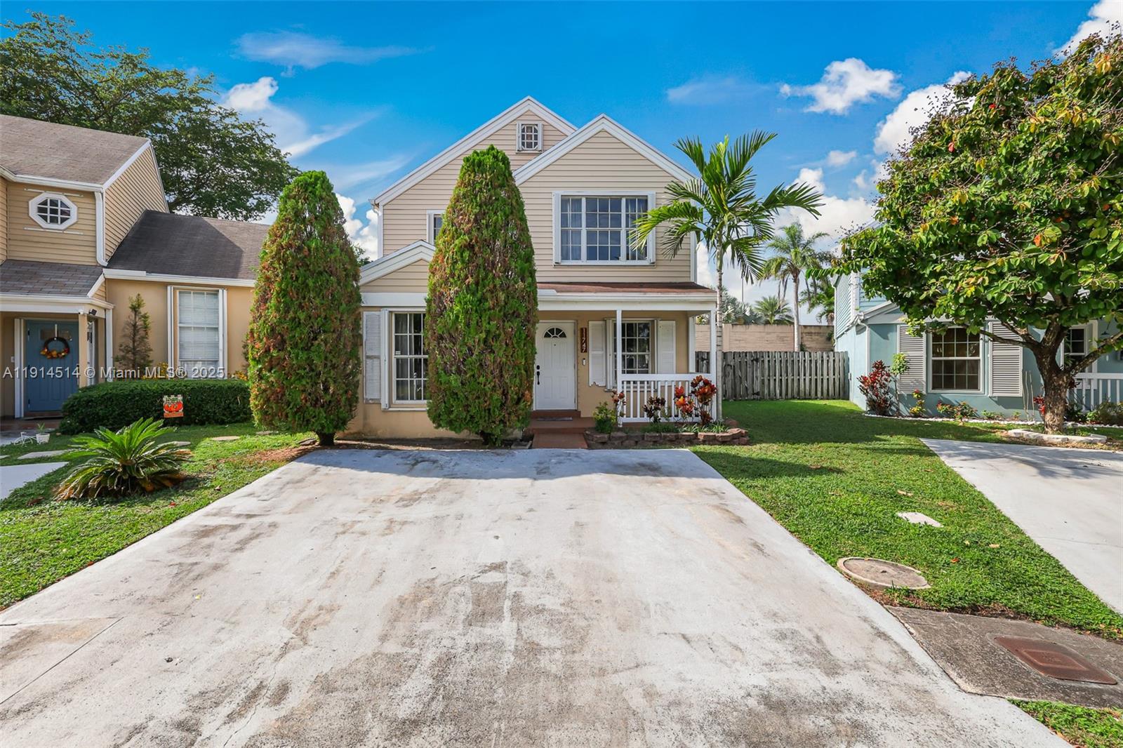 a front view of a house with a yard and potted plants