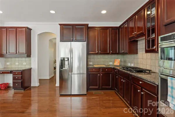 a kitchen with granite countertop cabinets and a stove top oven