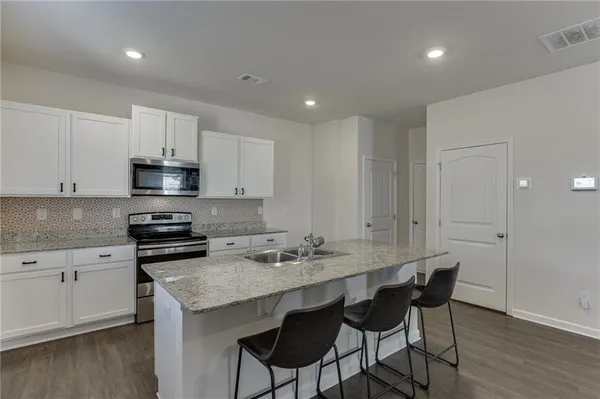 a kitchen with a sink cabinets and wooden floor