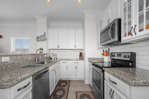 a kitchen with stainless steel appliances granite countertop a sink stove and cabinets